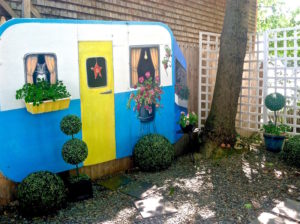 yard decor with handpainted cat, trailer, flowers.
